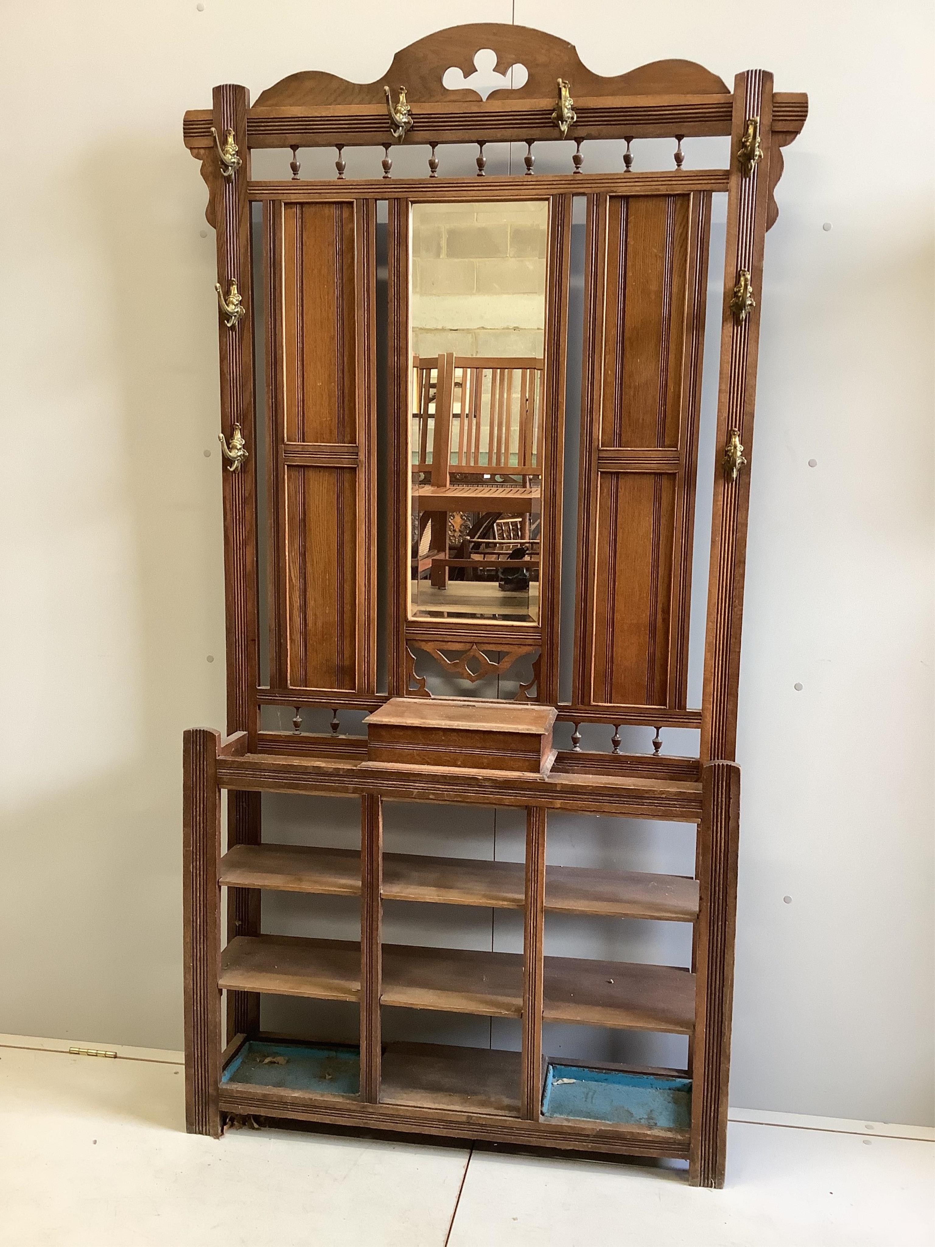 A late Victorian oak hallstand with cast brass elephant head hooks, width 115cm, height 210cm. Condition - fair